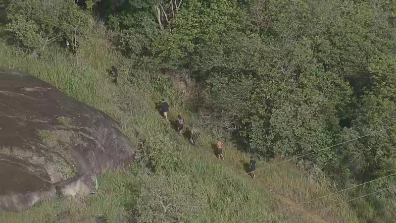 Bandidos com fuzis fogem pela mata durante operação no Morro do Fubá
