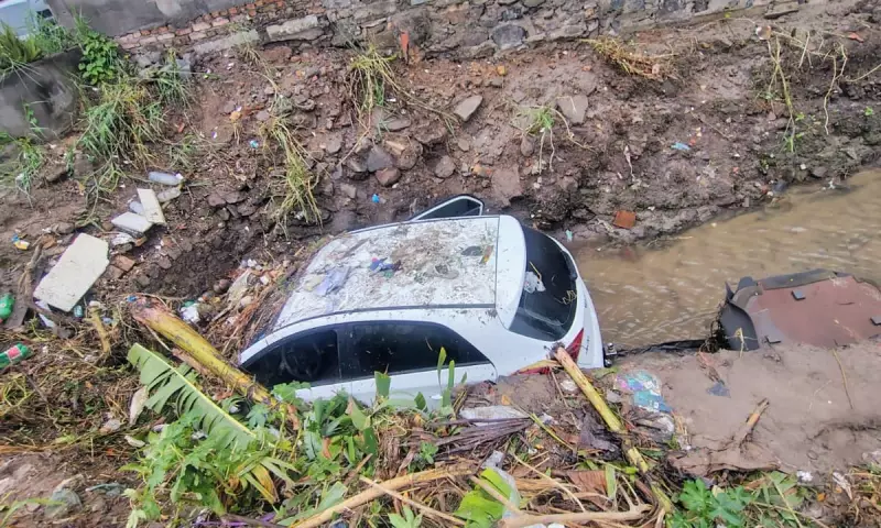 Carro é arrastado por enxurrada e cai em córrego durante chuva em Feira de Santana
