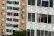 Mulher é flagrada em pé no parapeito de prédio durante limpeza em Santos, SP
