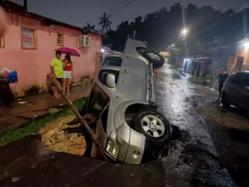 Carro com três ocupantes despenca em cratera em rua de Manaus; moradores protestam