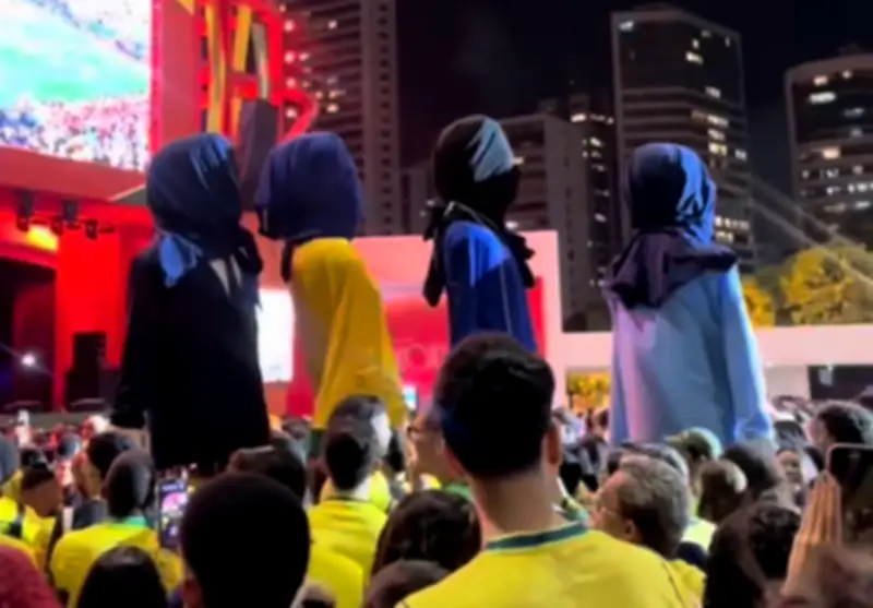 Bonecos gigantes deixam festa com cabeças cobertas após eliminação do Brasil na Copa
